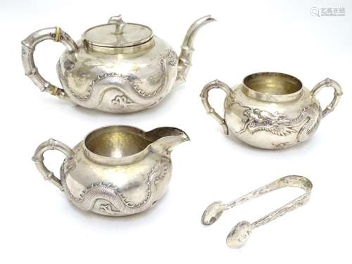 Chinese Export silver : A white metal three piece teaset comprising teapot, milk jug and sugar