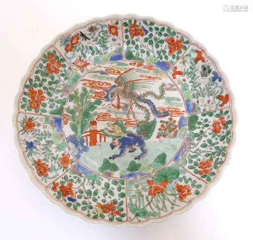 A Chinese plate with a lobed rim and hand painted famille verte decoration, the central section with