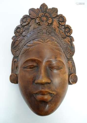 A Chinese carved wooden mask depicting a female face with a floral headdress. Approx. 10 3/4