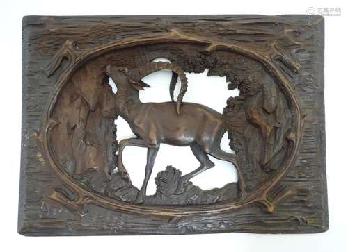 A 20thC Black Forest style carved wooden panel with openwork detail, depicting a woodland scene with