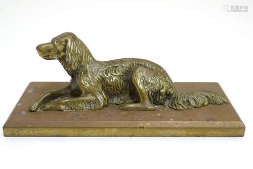 A late 19th / early 20thC cast paperweight formed as a recumbent dog on a rectangular plinth.