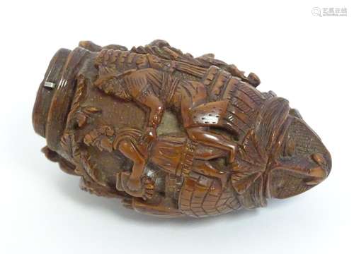 A Continental carved nut snuff bottle with two stylised faces to each end, the body carved with