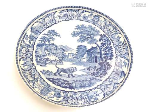 A blue and white pearlware cake stand decorated in the pattern The Angry Lion, depicting a landscape