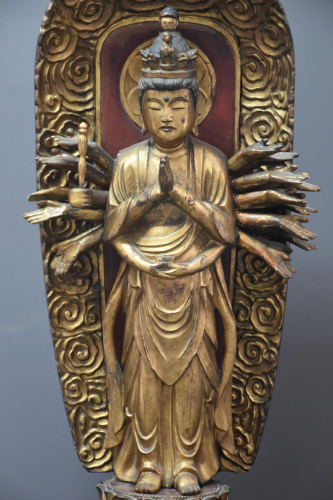 Deity on lotus flowers in carved and gilded wood.