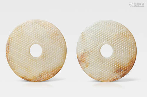 A very rare pair of large white and russet jade discs, bi Late Warring States/mid Western Han Dynasty