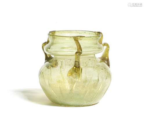 A Roman olive green glass jar