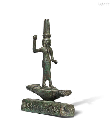 An Egyptian bronze figure of Onuris standing on a boat