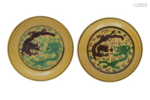 A NEAR PAIR OF CHINESE YELLOW-GROUND GREEN AND AUBERGINE 'DRAGON' DISHES.