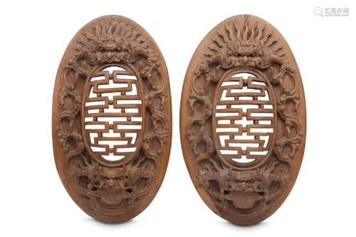 A PAIR OF WOOD CARVED OVAL PANELS.