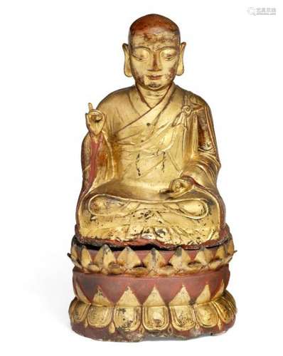 A Sino-Tibetan gilt-laquer and red-painted bronze figure of a Luohan seated on a [...]