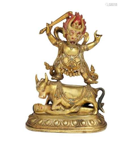 A Tibetan gilt and painted bronze figure of a striding ithyphallic Yama Dharmaraja. [...]