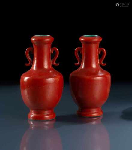 Paar korallrot glasierte Vasen aus Porzellan mit seitlichen Handhaben