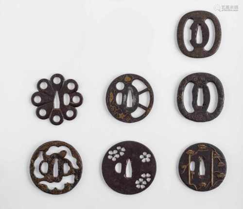 Konvolut von sieben Tsuba aus Eisen mit verschiedenen Dekoren