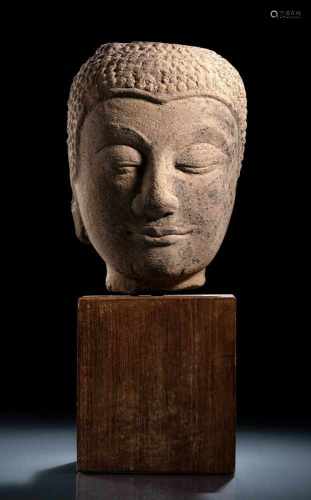 Kopf des Buddha aus hellbeigem Sandstein auf einen Holzsockel montiert