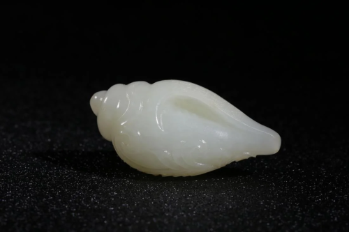 A WHITE JADE CARVING 'CONCH' ORN…