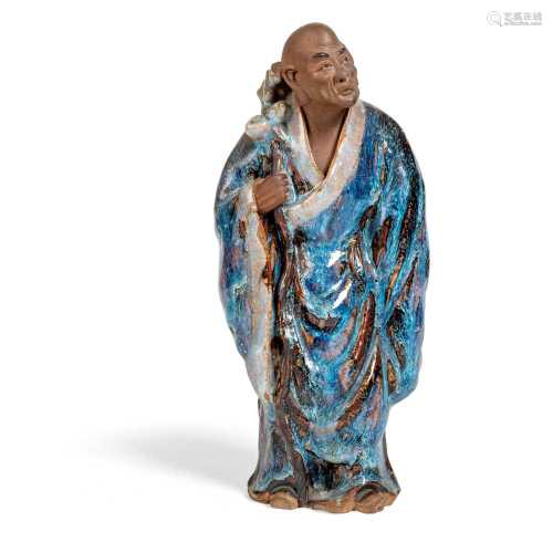 FLAMBE-GLAZED SHIWAN POTTERY FIGURE OF A MONK LATE QING DYNASTY-REPUBLIC PERIOD, 19TH-20TH CENTURY