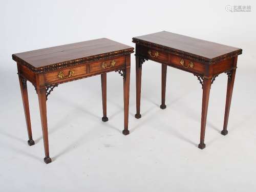 A pair of George III mahogany card tables, the hinged rectangular tops with oval and foliate