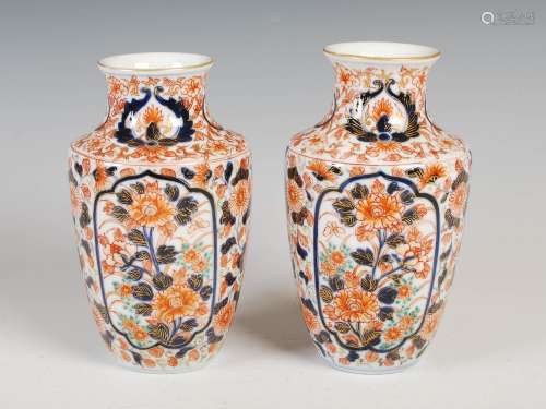 A pair of Japanese Imari porcelain vases, decorated with oval shaped panels of peony on a