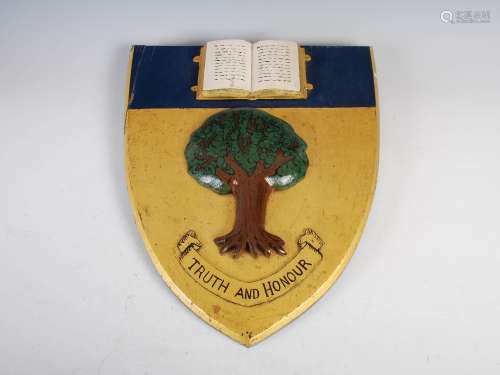 A carved painted and gilt wood crest for Feldon School, Milverton Hill, Leamington Spa, carved in