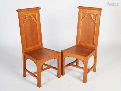 A pair of early 20th century oak Gothic presentation altar chairs, the rectangular panelled backs