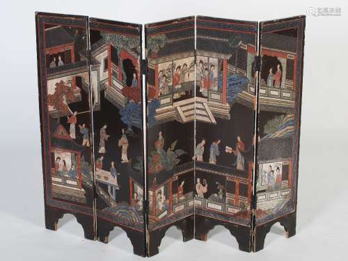 A late 19th/early 20th century Chinese lacquered five fold screen of small size, with carved