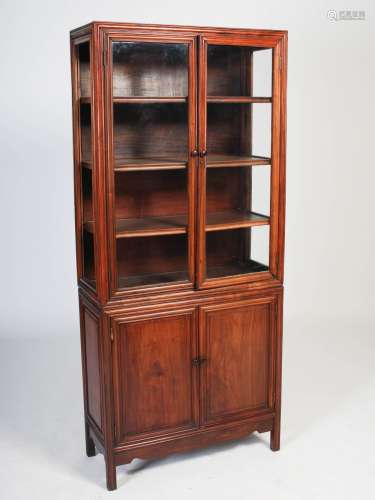 A Chinese dark wood two part display cabinet, late 19th/early 20th century, the upper part with