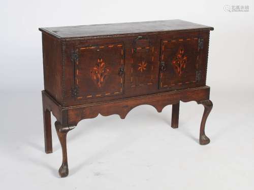 An Arts & Crafts oak and marquetry inlaid cabinet on stand, the cabinet section with rectangular top