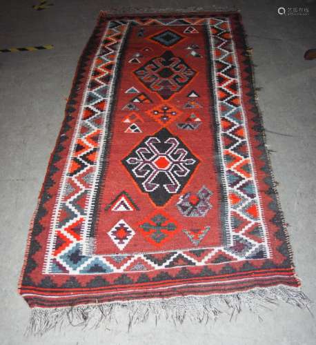 A Kelim long rug, 20th century, the rectangular madder ground centred with two large lozenge