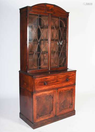 A George III mahogany and boxwood lined secretaire bookcase, the arched cornice centred with a
