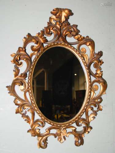 A late 19th/early 20th century Florentine gilt wood Rococo style wall mirror, the pierced carved
