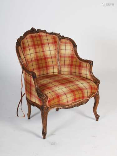 A late 19th century Louis XVI style carved walnut fauteuil, with tartan upholstered panelled back