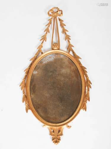 A Neo Classical style gilt wood wall mirror, the oval mirror plate suspended from ribbon tie and