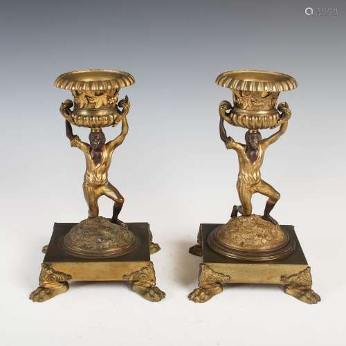 A pair of 19th century gilt bronze twin handled urns, supported on figural columns and square