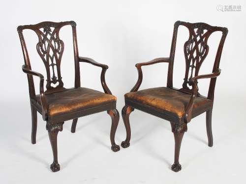 A pair of late 19th/early 20th century George III style mahogany elbow chairs, the shaped top