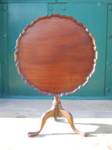 A George III mahogany snap top occasional table, the hinged circular top with scalloped edge, raised