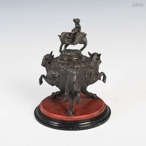 A 19th century bronze inkwell, cast with three rampant bulls divided by satyr masks, the