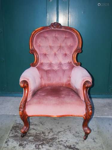 A Victorian mahogany parlour chair, the pink velvet upholstered button down back, arms and seat