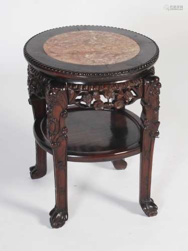 A Chinese dark wood urn stand, Qing Dynasty, the circular top with a mottled red and white marble