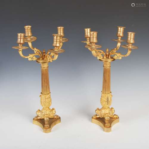 A pair of 19th century gilt bronze four light candelabra, the urn shaped nozzles supported on scroll