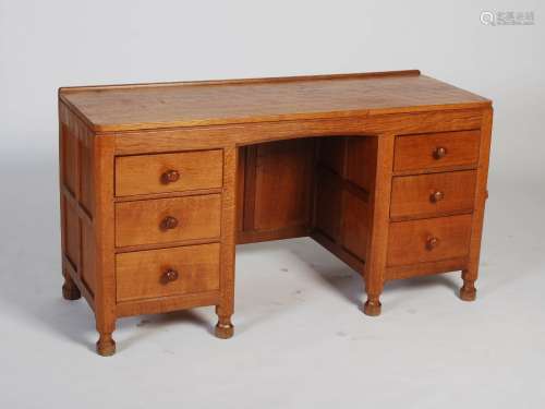 Mouseman - An oak knee hole desk, the rectangular adzed top above a central knee hole flanked by