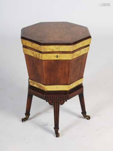 A George III mahogany and brass bound octagonal shaped wine cooler on integral stand, the hinged