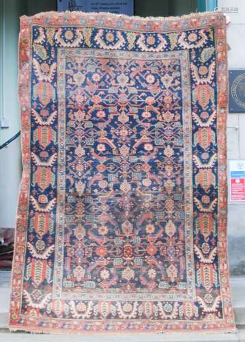 A Persian rug, late 19th/early 20th century, the rectangular abrashed blue ground field decorated