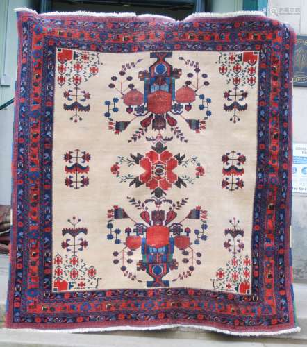 A Persian rug, late 19th/early 20th century, the rectangular sand coloured ground centred with a