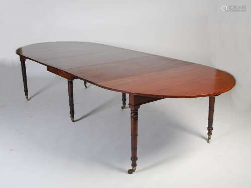 A 19th century Regency style mahogany extending dining table, the D-ends extending to enclose