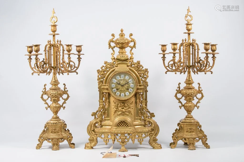 Mantle clock with candelabra, made of bronze.