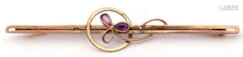 9ct stamped amethyst brooch of open work design, centring an amethyst set flower (one stone missing)