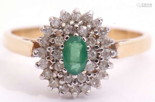 18ct gold emerald and diamond cluster ring, centring an oval faceted cut emerald raised above two