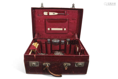 Edwardian red morocco leather travelling case with some original fittings including four silver