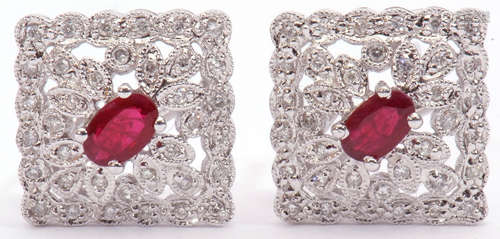 Pair of diamond and ruby cluster earrings, an off-square design centring an oval faceted ruby within