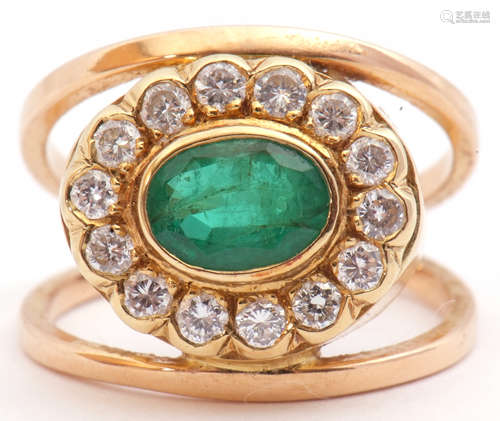 Emerald and diamond cluster ring, a stylised design, the centre with an oval faceted emerald, 8mm